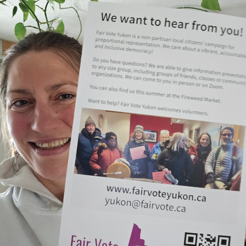 Fair Vote Yukon supporter holds a flyer